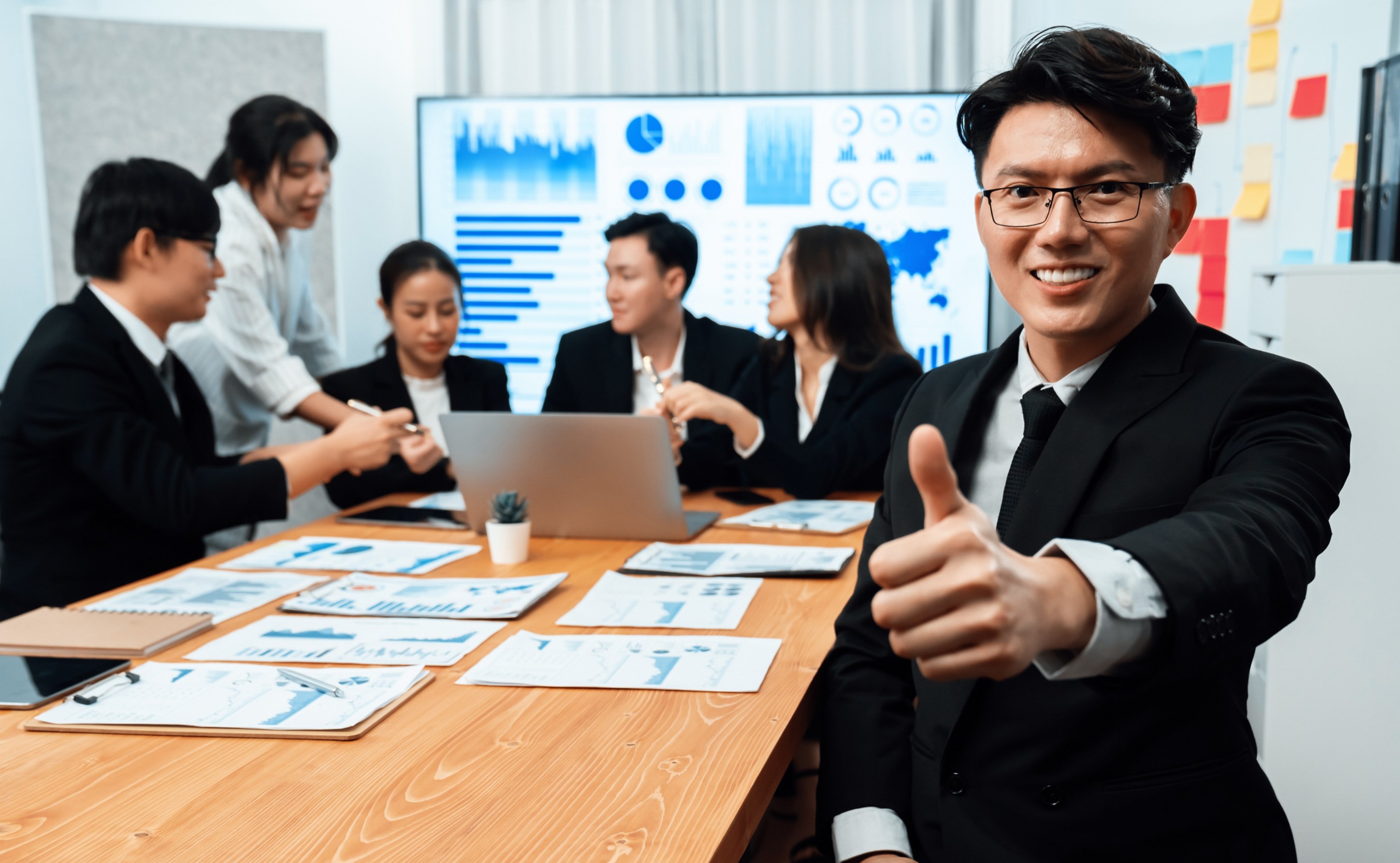 focus-portrait-male-manager-harmony-office-with-businesspeople-background